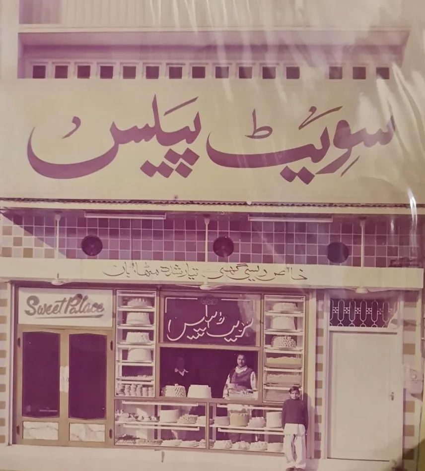 The original Sweet Palace shop on Murree Road, with its Urdu signboard and trays of mithai in the window